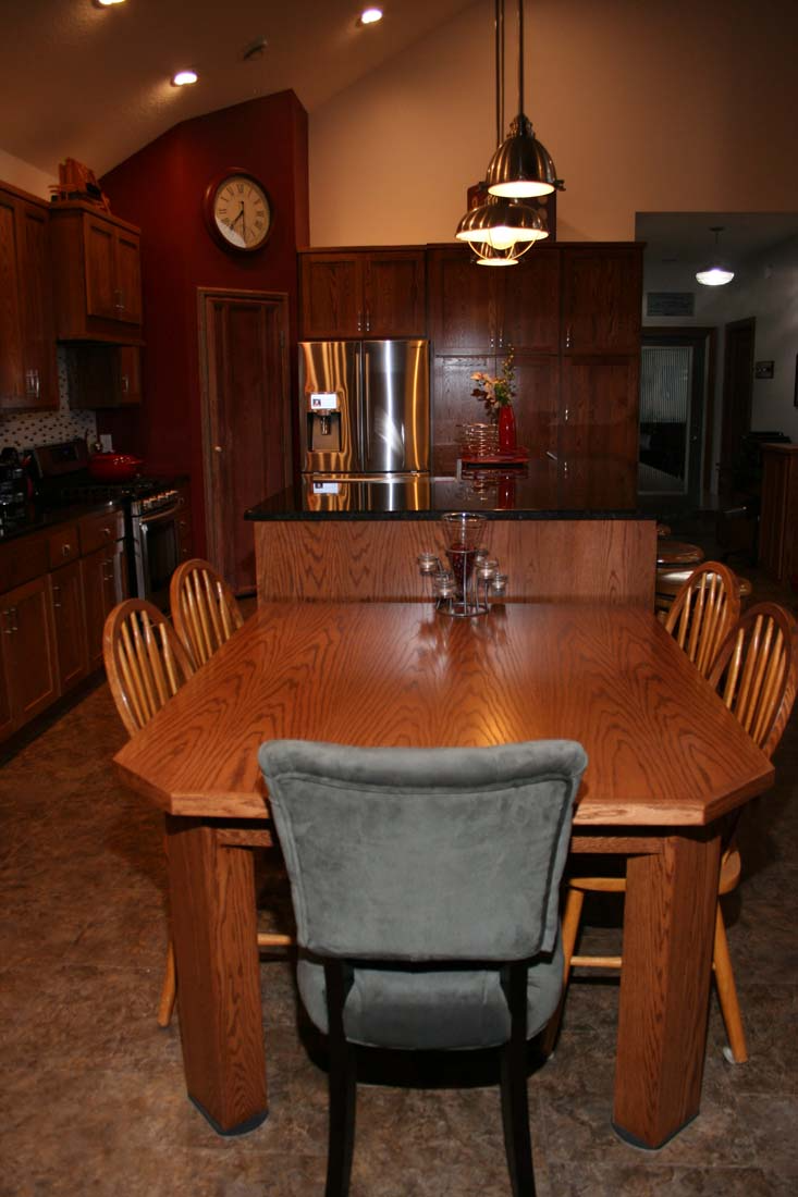A kitchen with a table and chairs and a clock on the wall