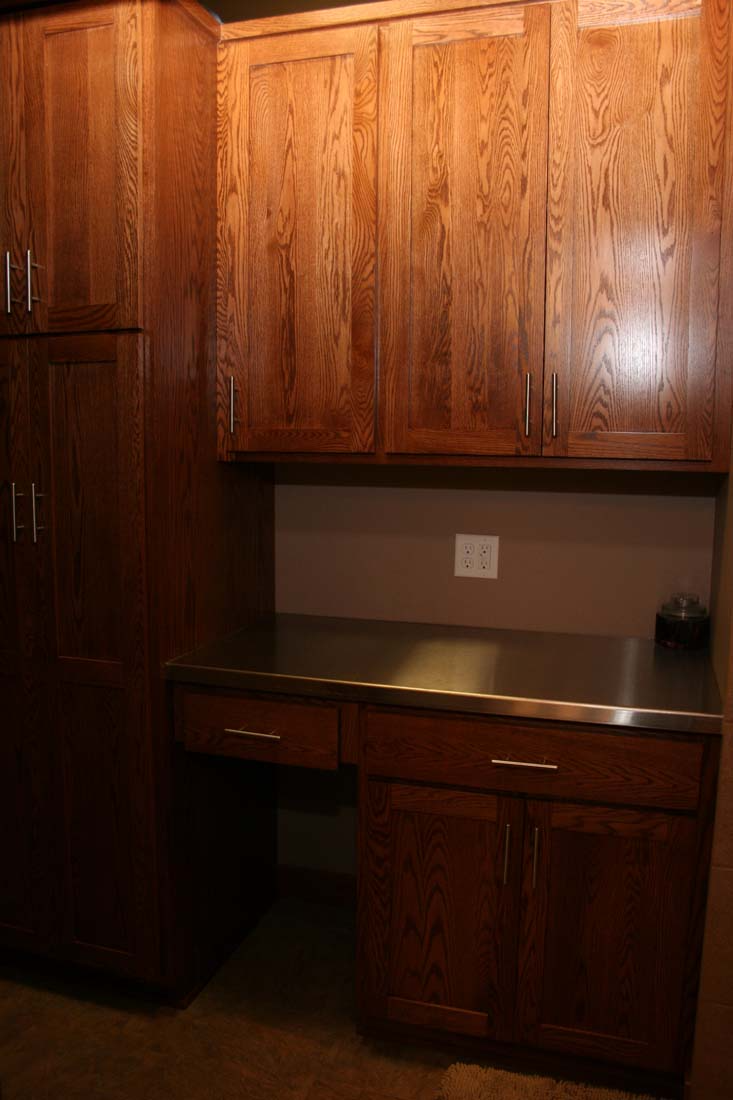 A kitchen with wooden cabinets and a stainless steel counter top.
