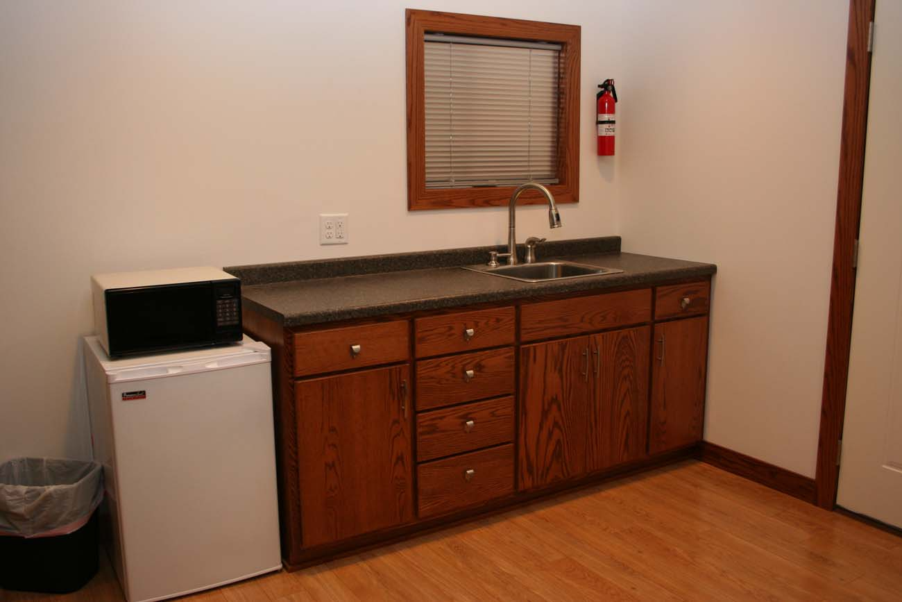 A kitchen with a sink , microwave and refrigerator