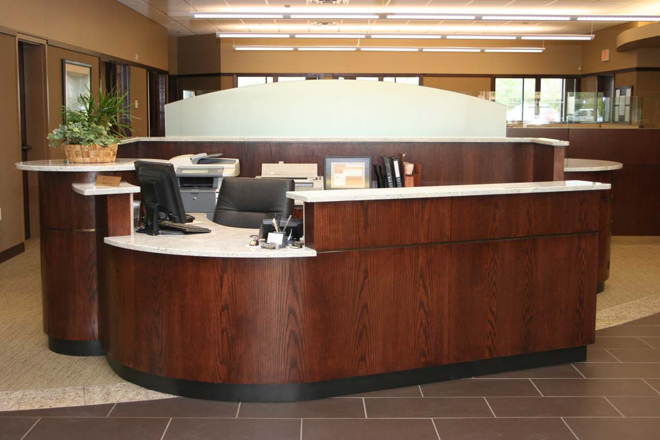 A large wooden reception desk with a computer on it
