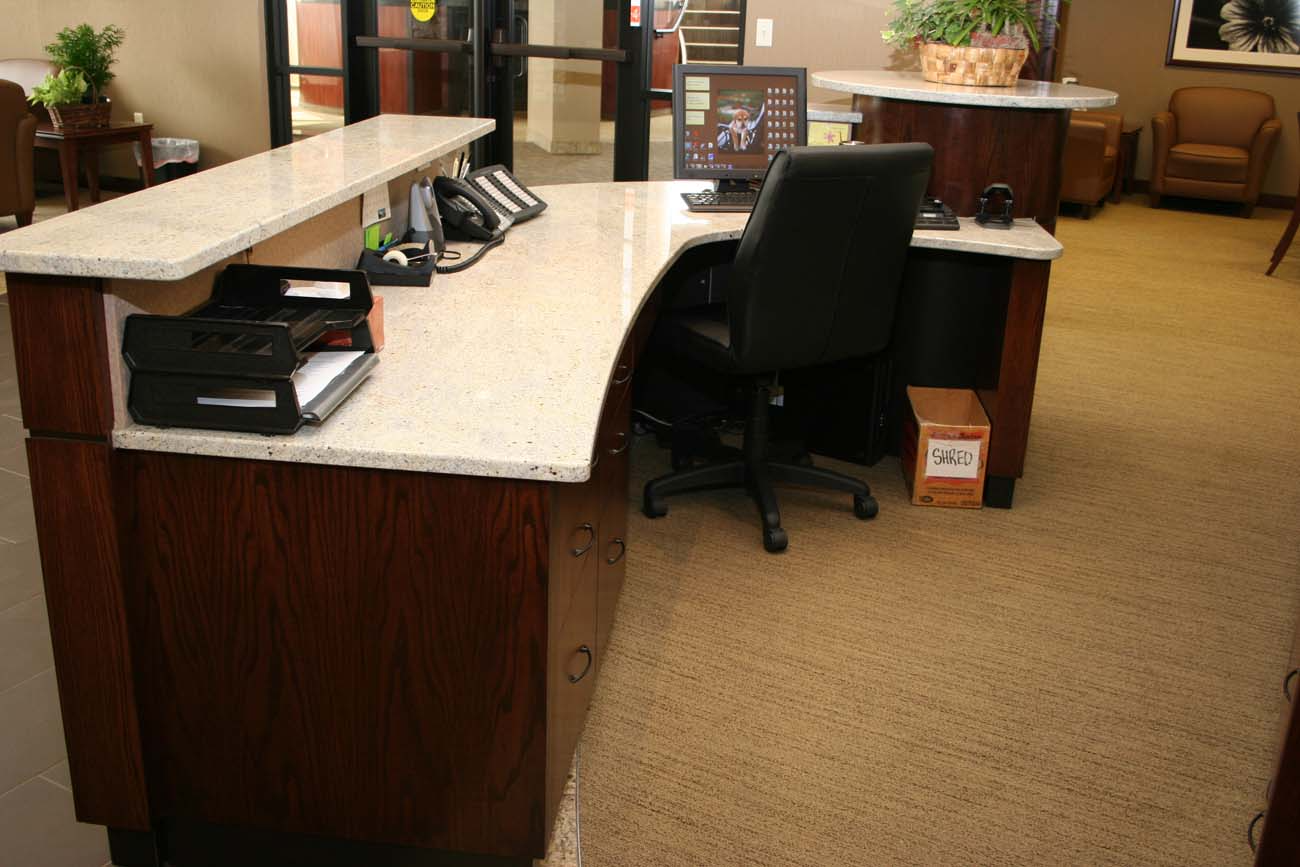 A reception desk with a computer on it and a chair