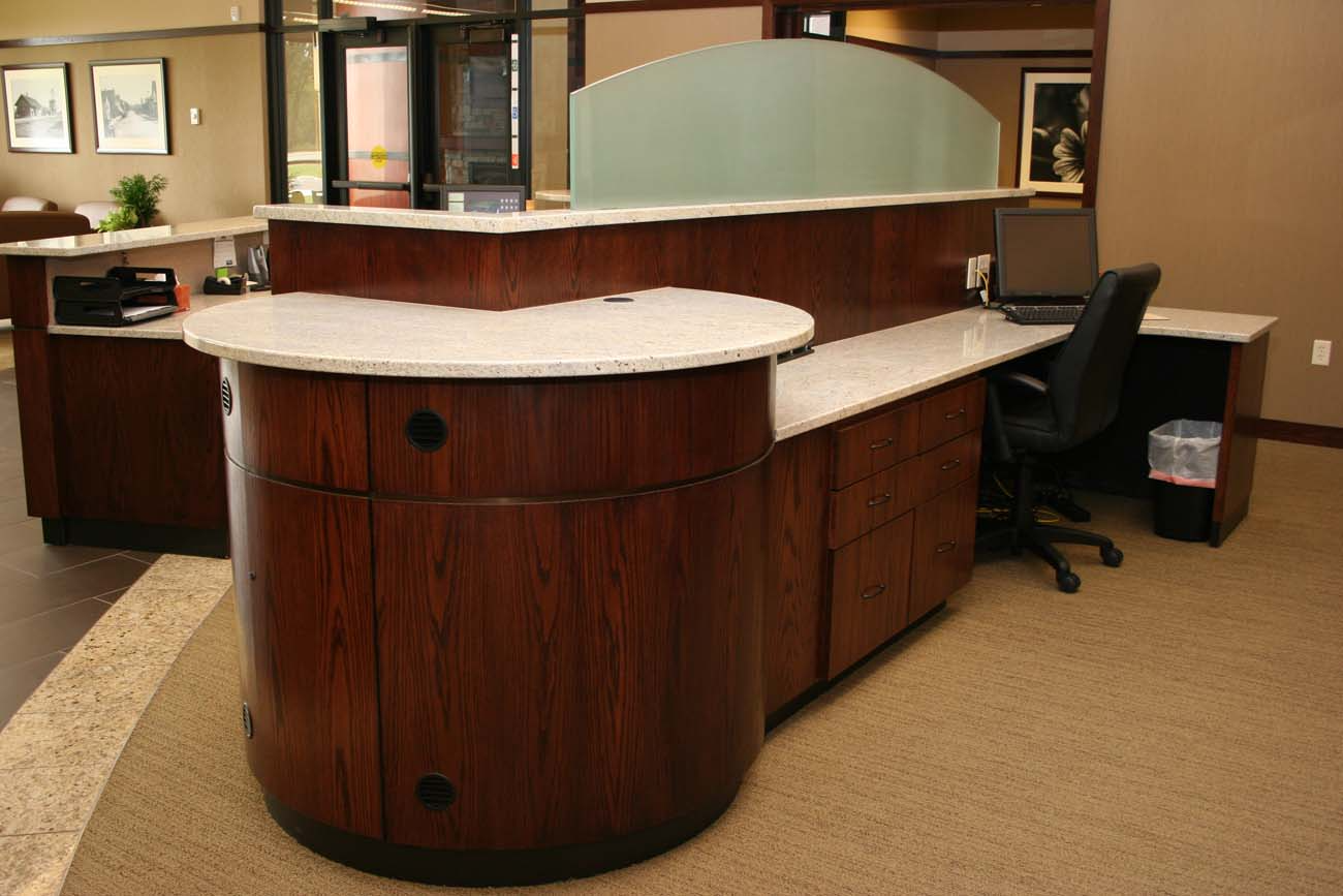 A reception area with a curved wooden counter top