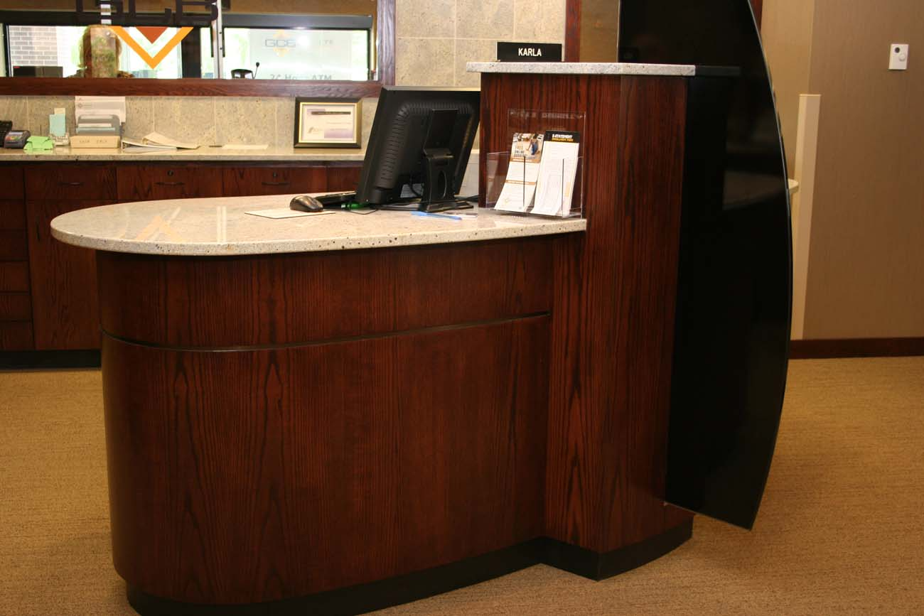 A wooden desk with a computer on top of it