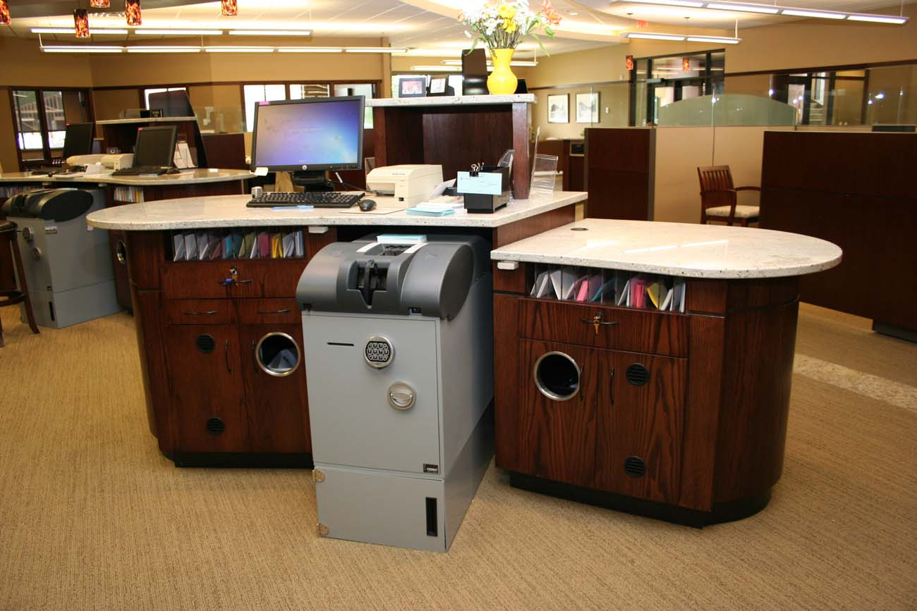 A desk with a computer and a cash machine on it