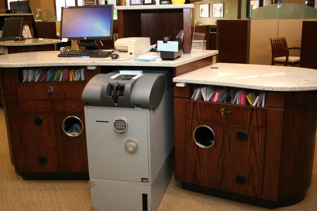 A computer is on a desk next to a cash machine