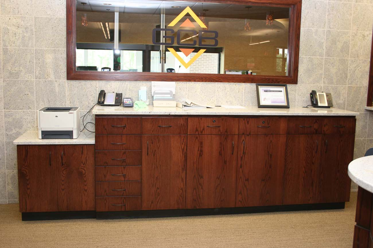 A large mirror in a room with wooden cabinets