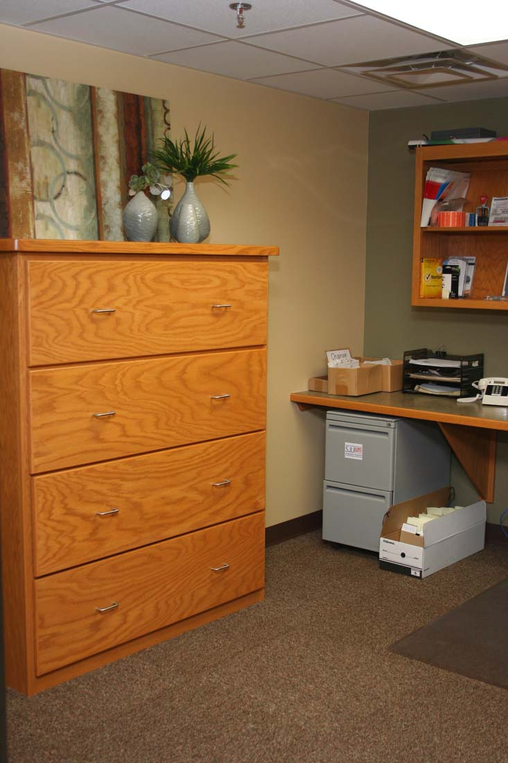 A room with a dresser and a desk in it