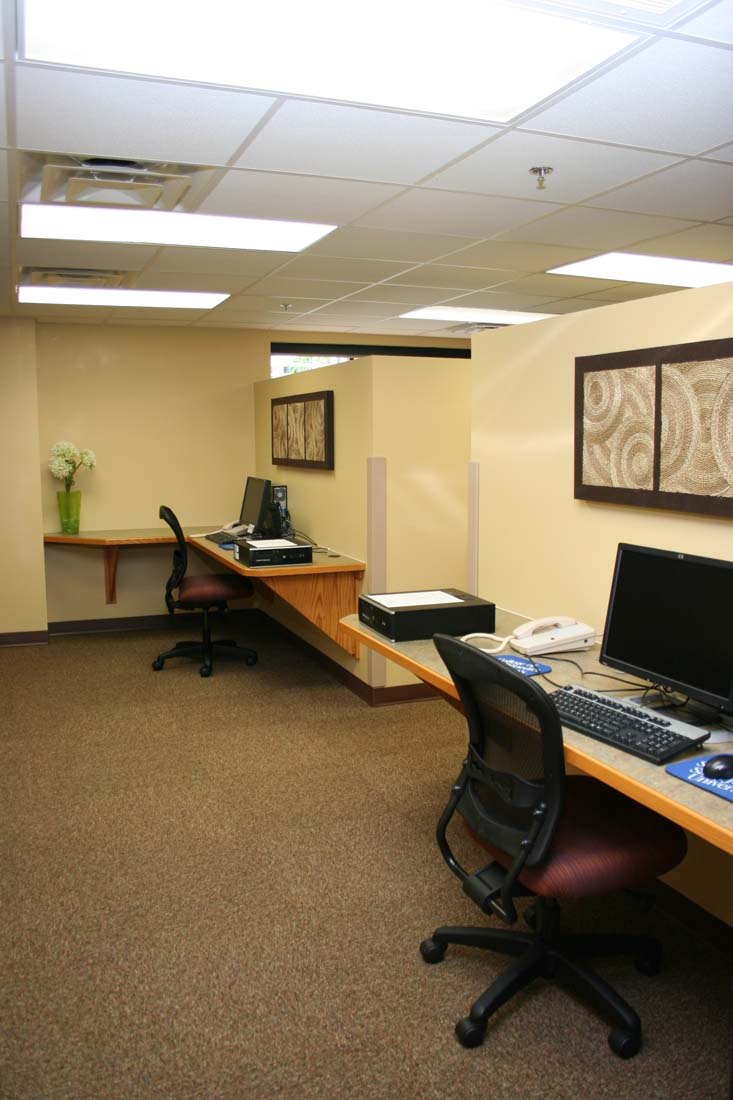 A room with two desks and two chairs with computers on them