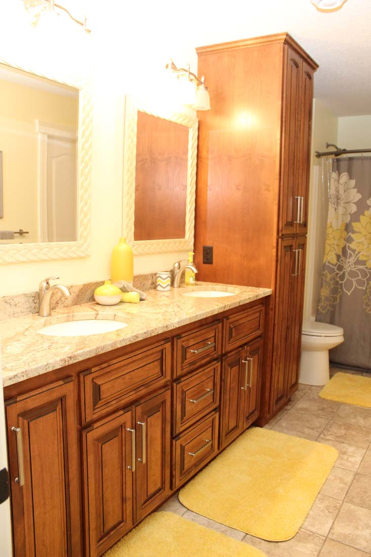 A bathroom with two sinks , a toilet , and a mirror.