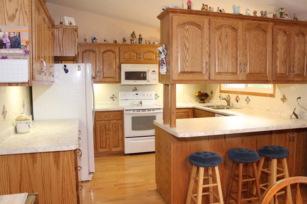 A kitchen with wooden cabinets and a white refrigerator
