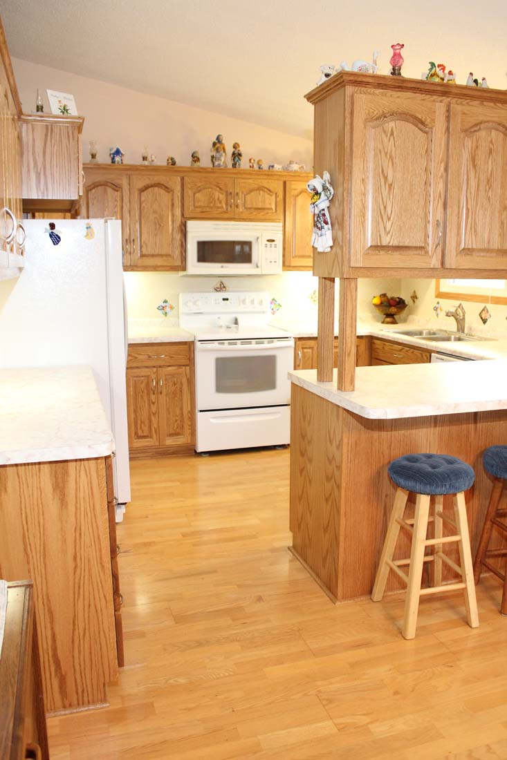 A kitchen with wooden cabinets and a white refrigerator