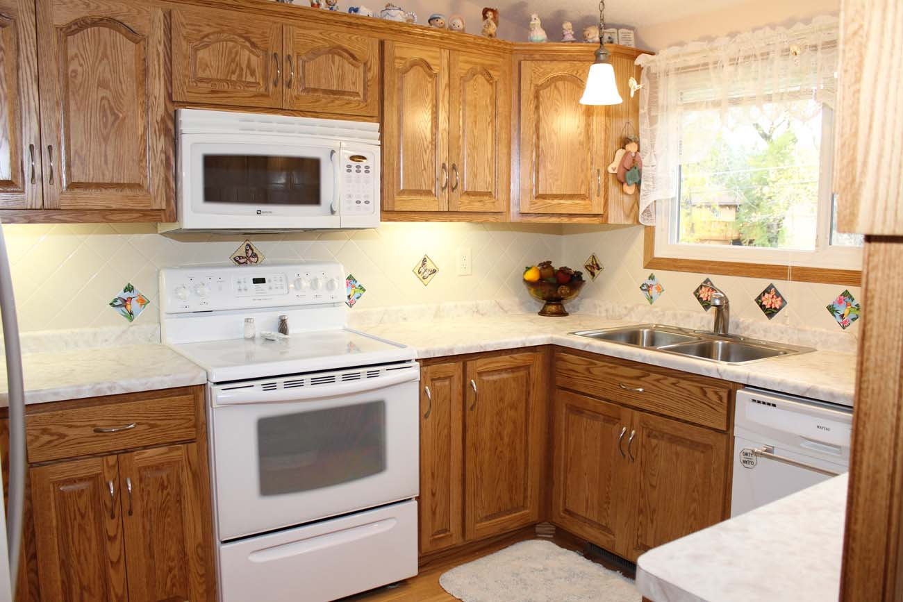 A kitchen with wooden cabinets and a white stove