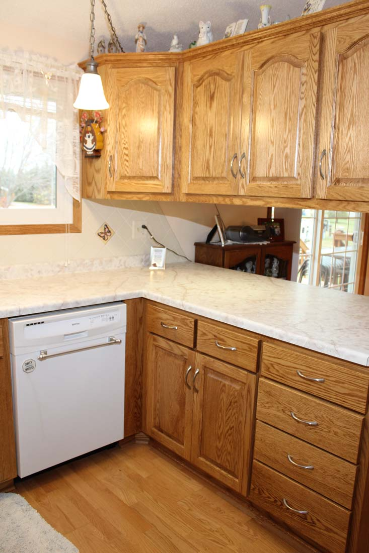 A kitchen with wooden cabinets and a white dishwasher