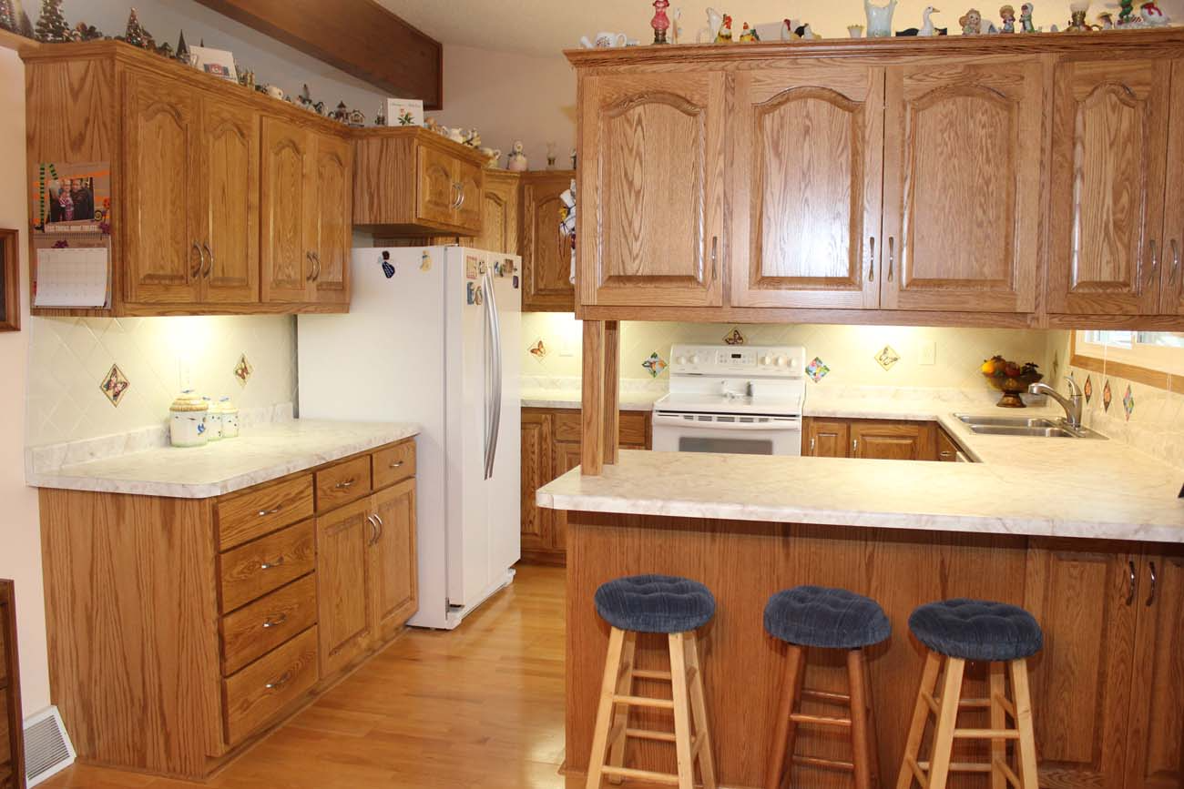A kitchen with wooden cabinets and a white refrigerator