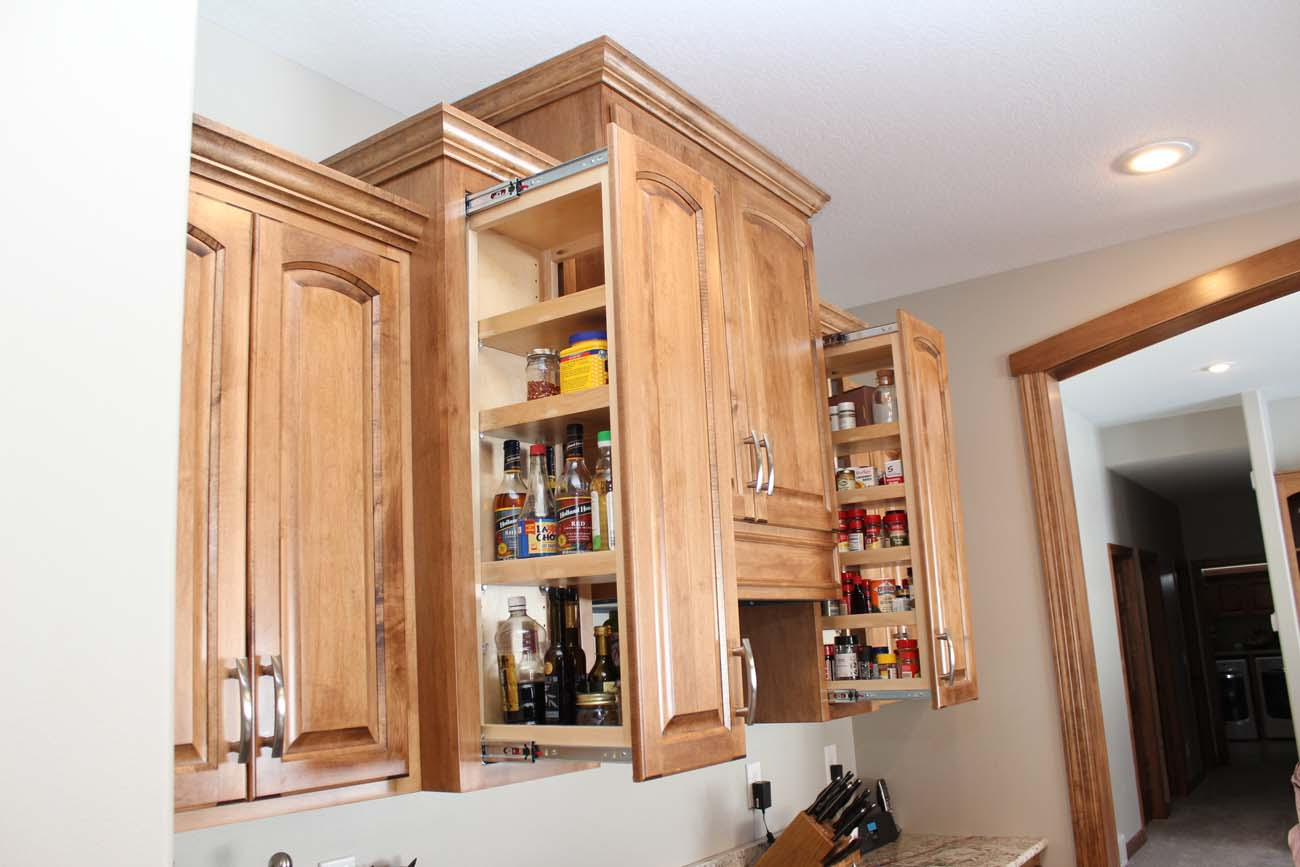 A kitchen with wooden cabinets and shelves filled with food.