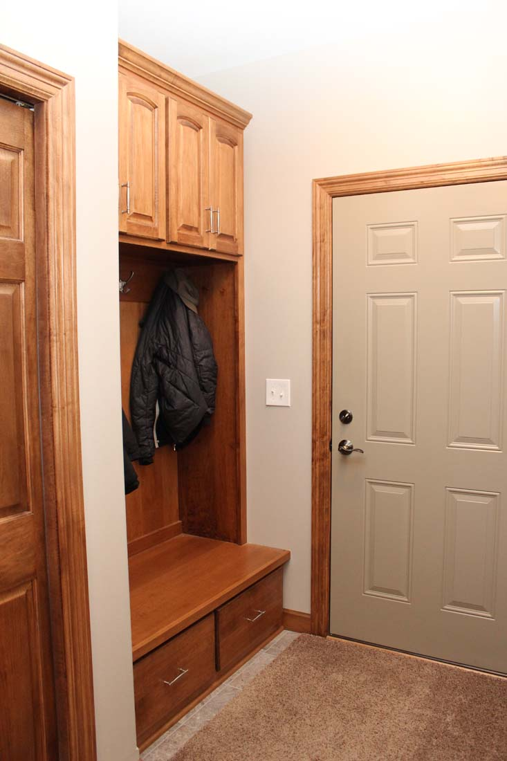 A hallway with a coat rack and a door