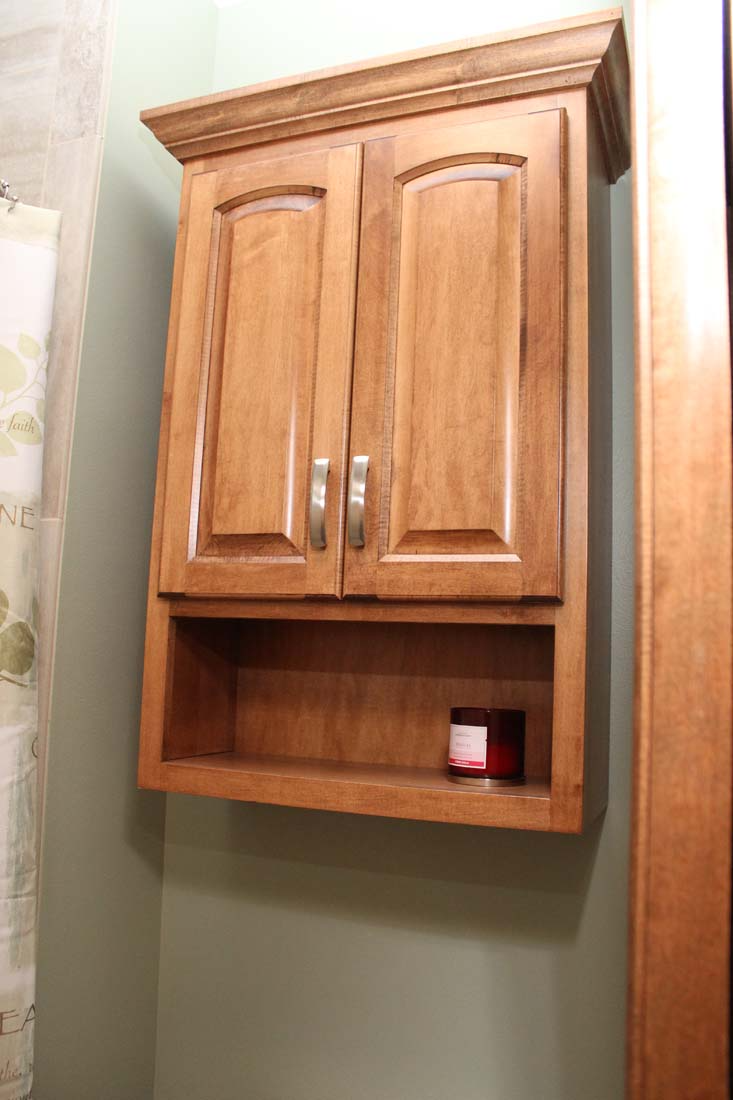 A bathroom cabinet with a shelf underneath it