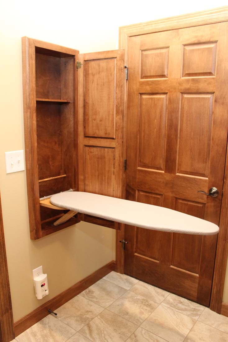 A room with a wooden door and an ironing board