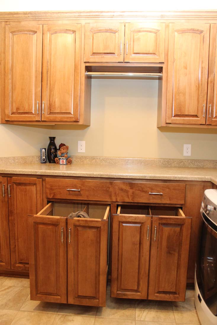 A kitchen with wooden cabinets and drawers and a stove.