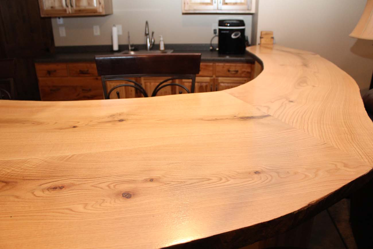 A kitchen with a curved wooden counter top