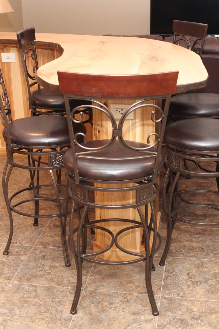 A wooden table with a wrought iron chair in front of it