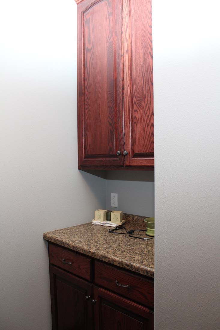 A kitchen with wooden cabinets and a granite counter top.