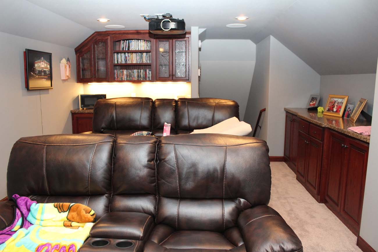 A living room with a brown leather couch and a yellow blanket