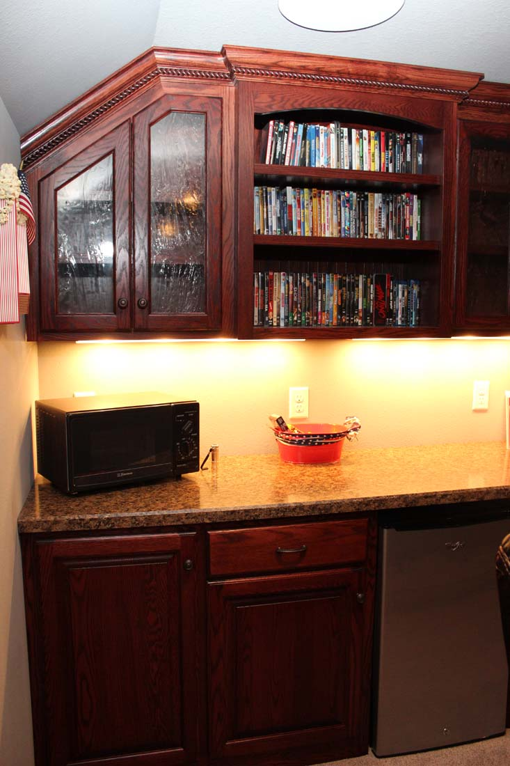 A kitchen with wooden cabinets and a microwave on the counter