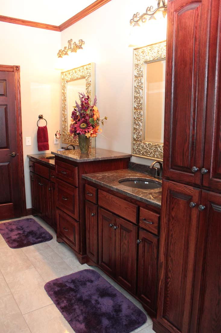A bathroom with wooden cabinets and purple mats