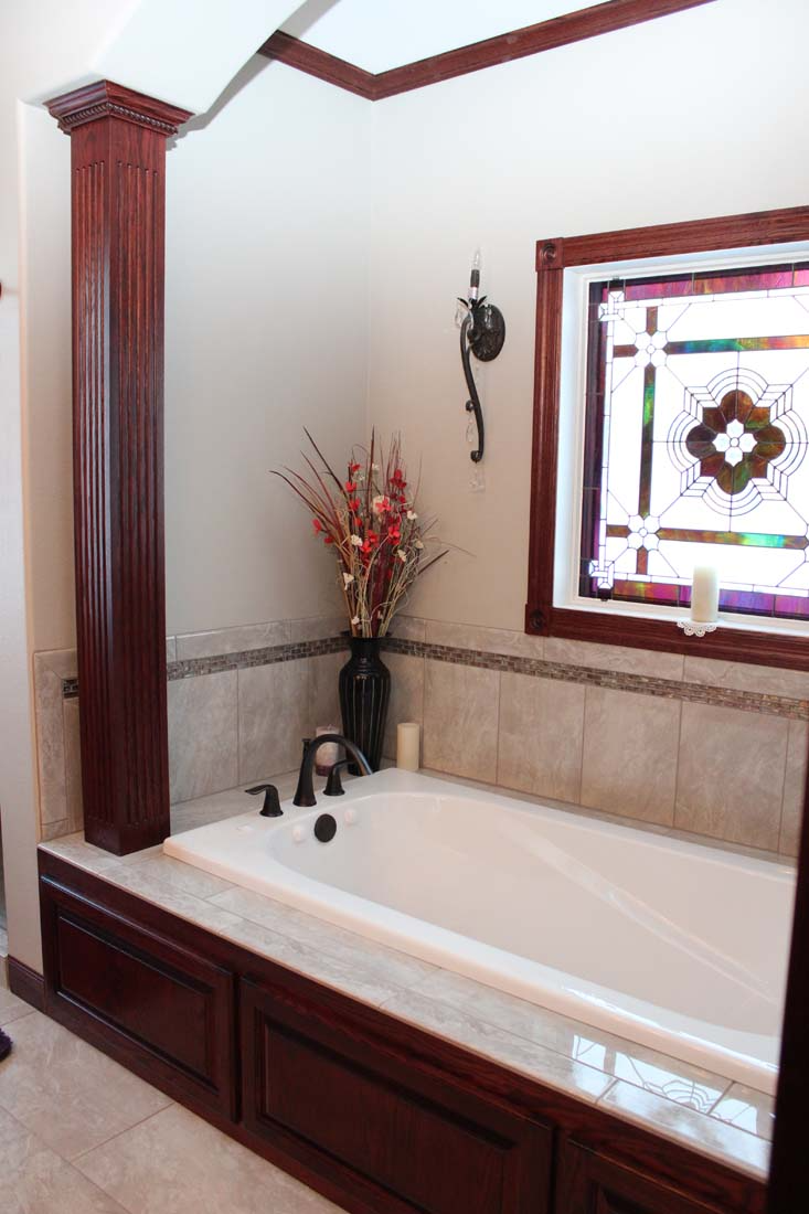 A bathroom with a tub and a stained glass window