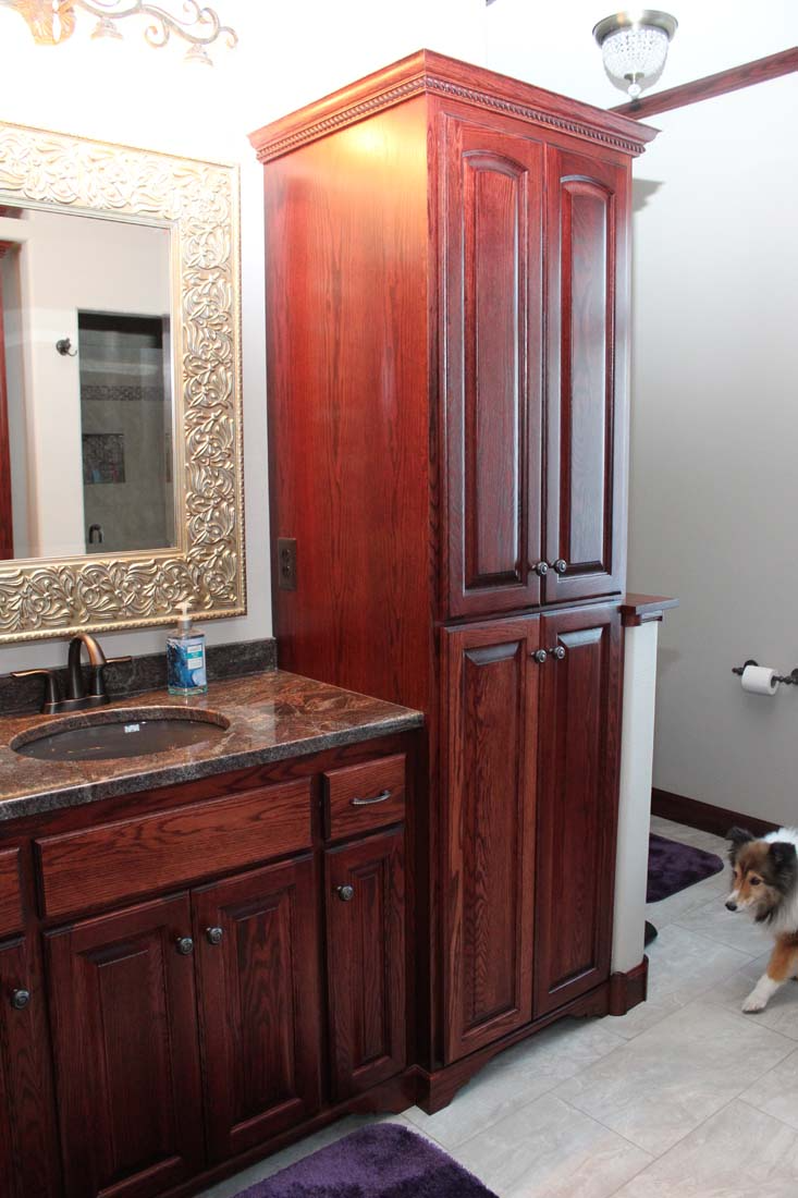 A bathroom with a sink , cabinets , and a mirror.
