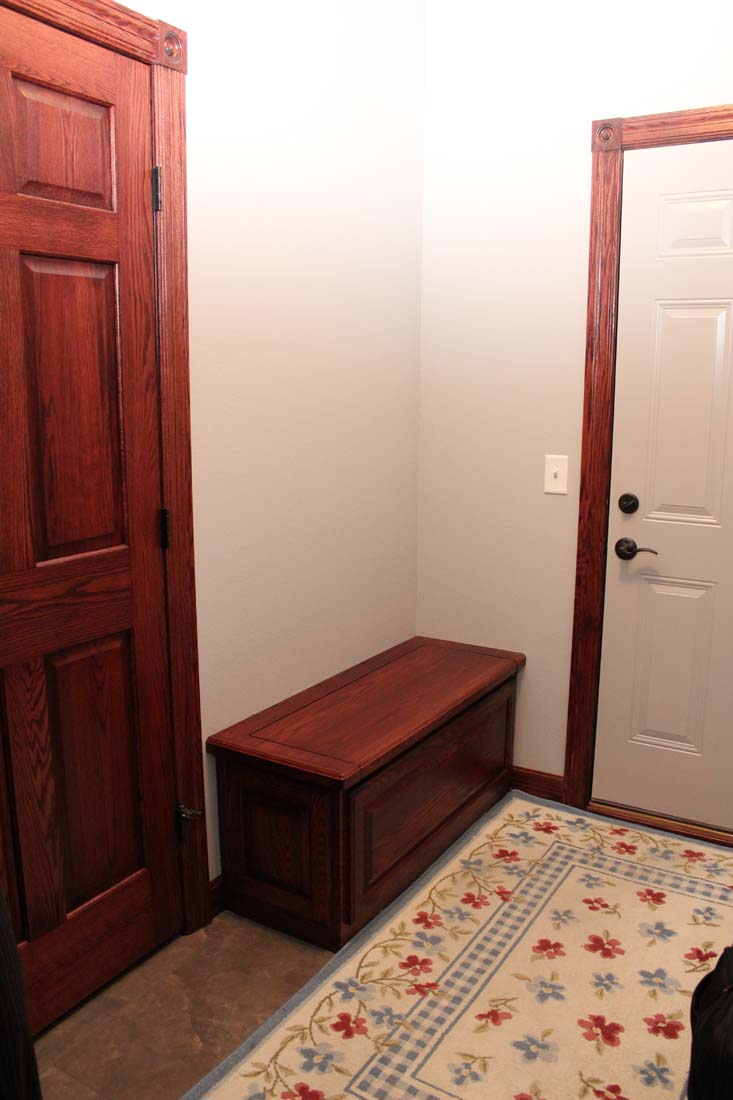 A wooden bench sits in a hallway next to a door