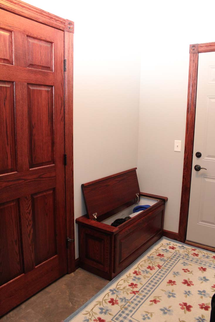 A wooden bench in a hallway next to a door