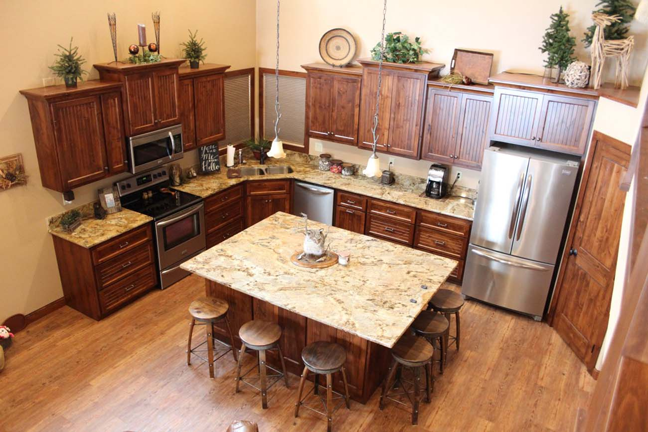 A kitchen with stools and a large island in the middle