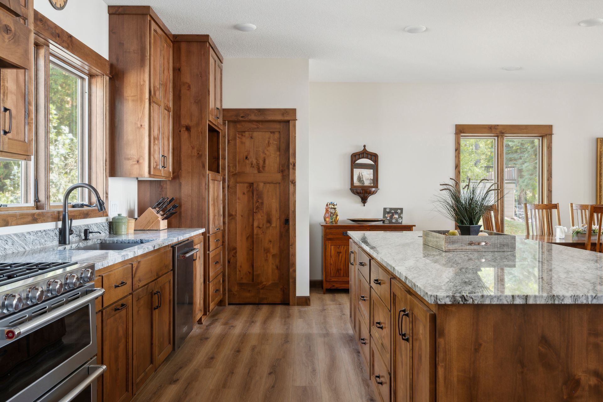 Bright modern kitchen with wood cabinets, granite island, and large windows.