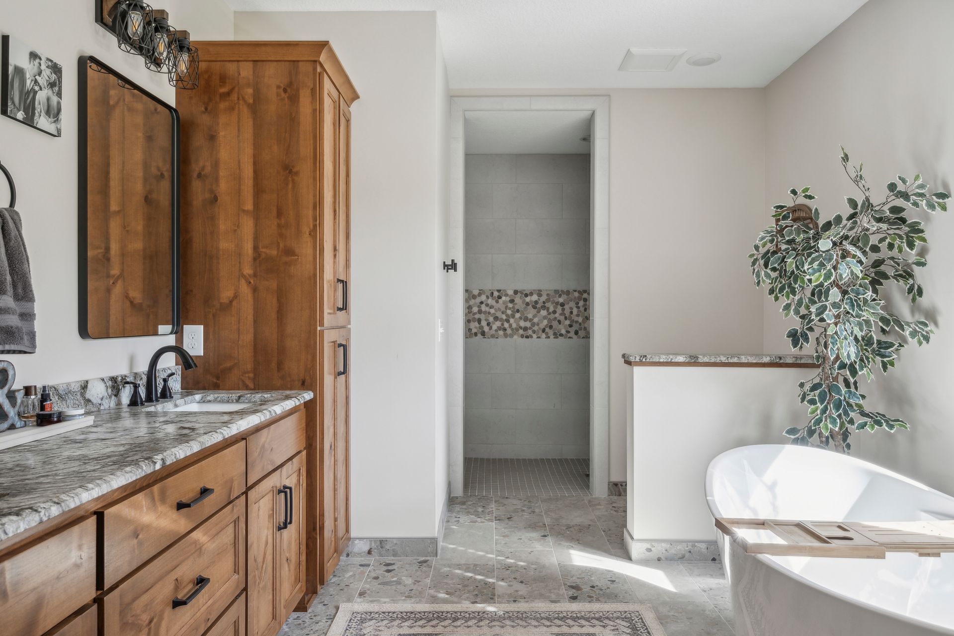 Bright modern bathroom with wood vanity, walk-in shower, and freestanding tub