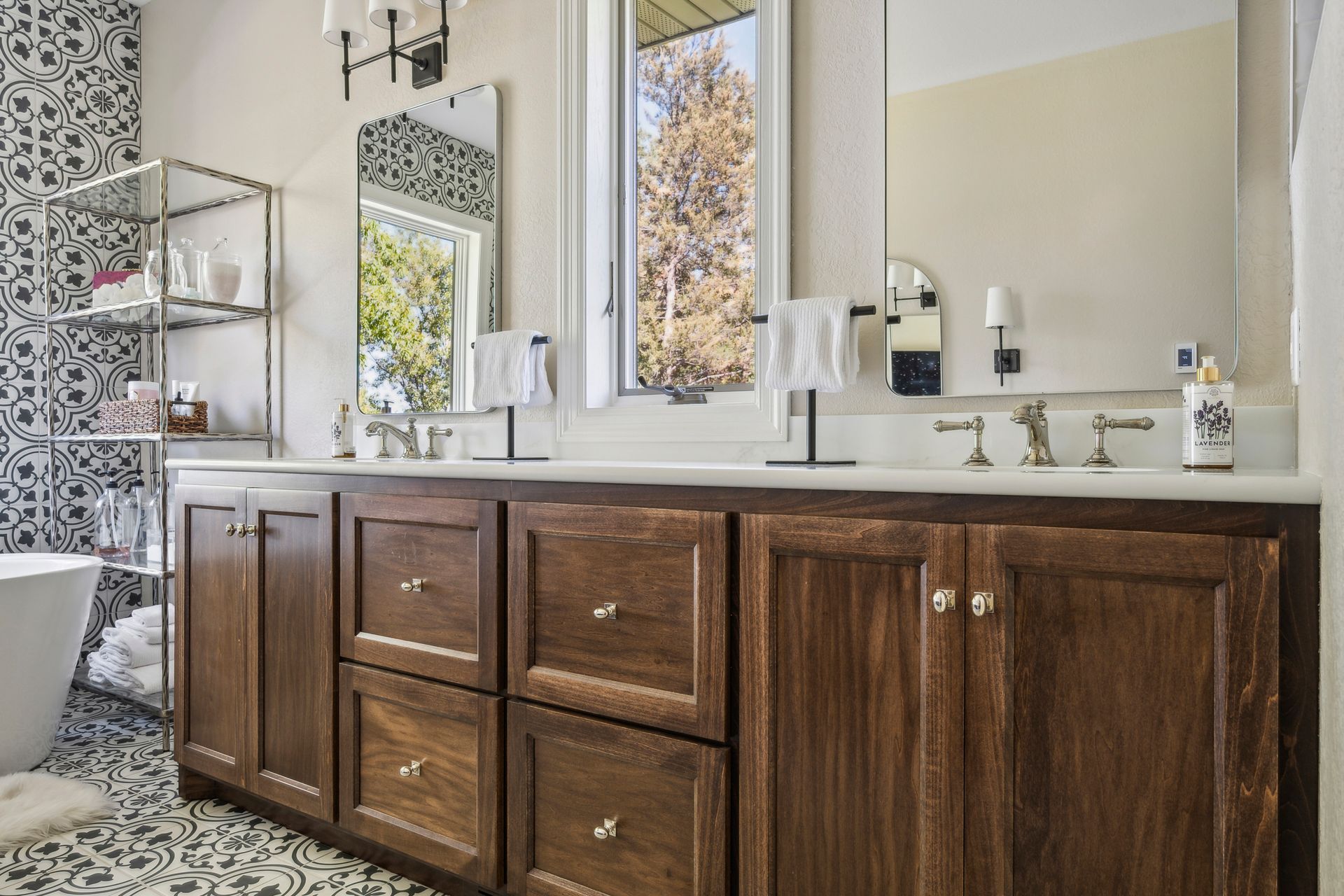 Modern bathroom with dark wood vanity, white countertop, large mirror, and windowed shower area