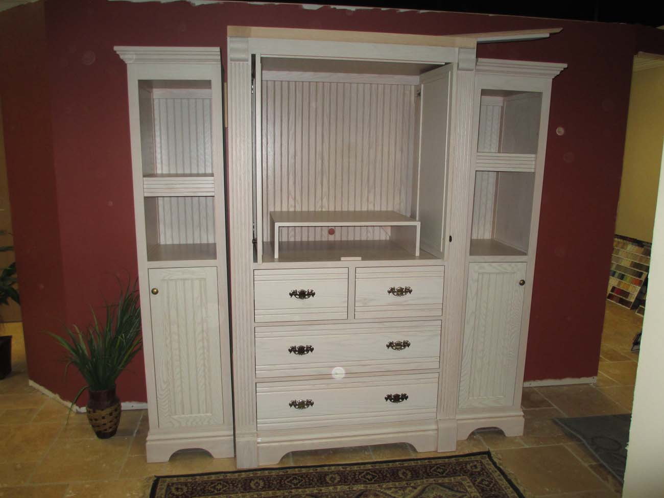 A large white cabinet with lots of drawers and shelves