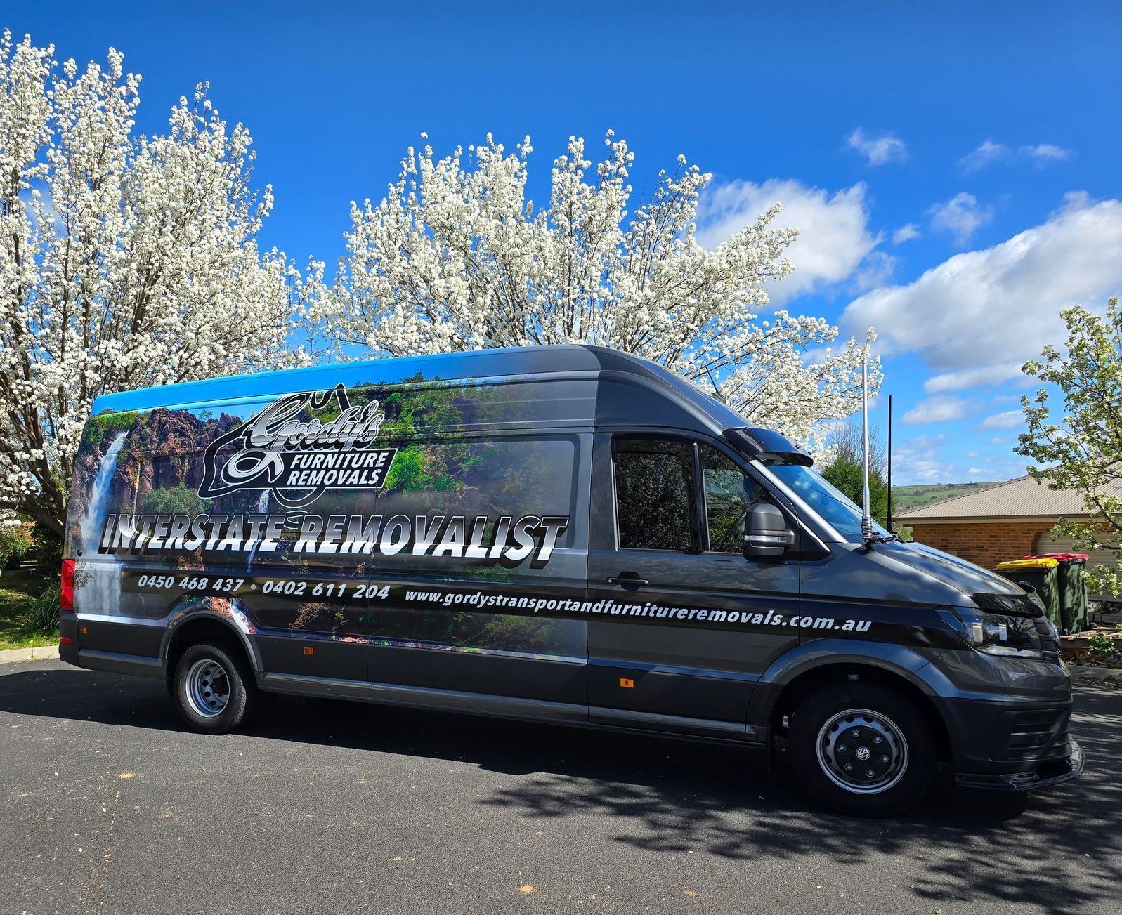 A Black Truck Inside A Trailer Truck — Gordy's Furniture Removals in Bathurst, NSW