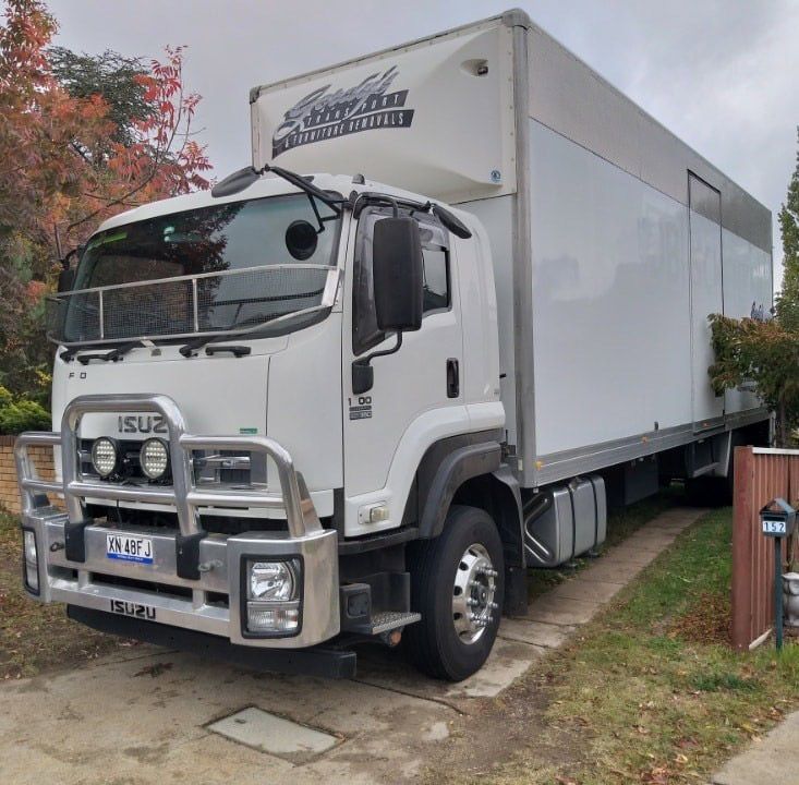 A White Isuzu Truck Is Parked In A Driveway — Gordy's Furniture Removals in Bathurst, NSW