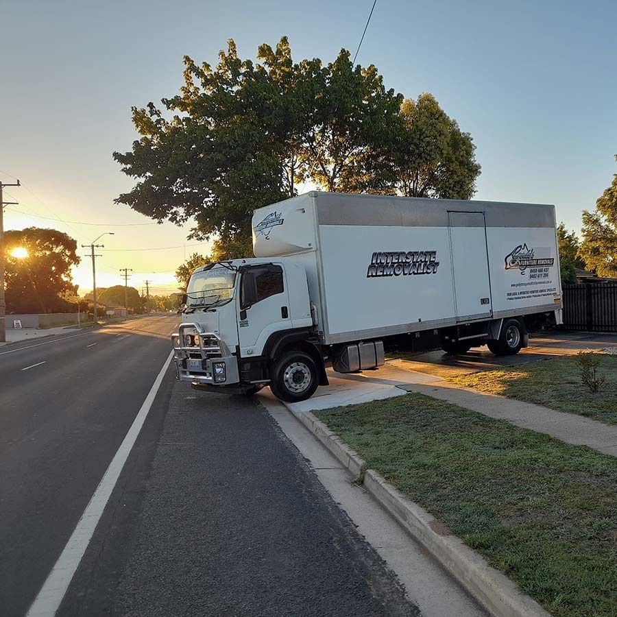 A White Moving Truck Is Parked On The Side Of The Road — Gordy's Furniture Removals in Bathurst, NSW