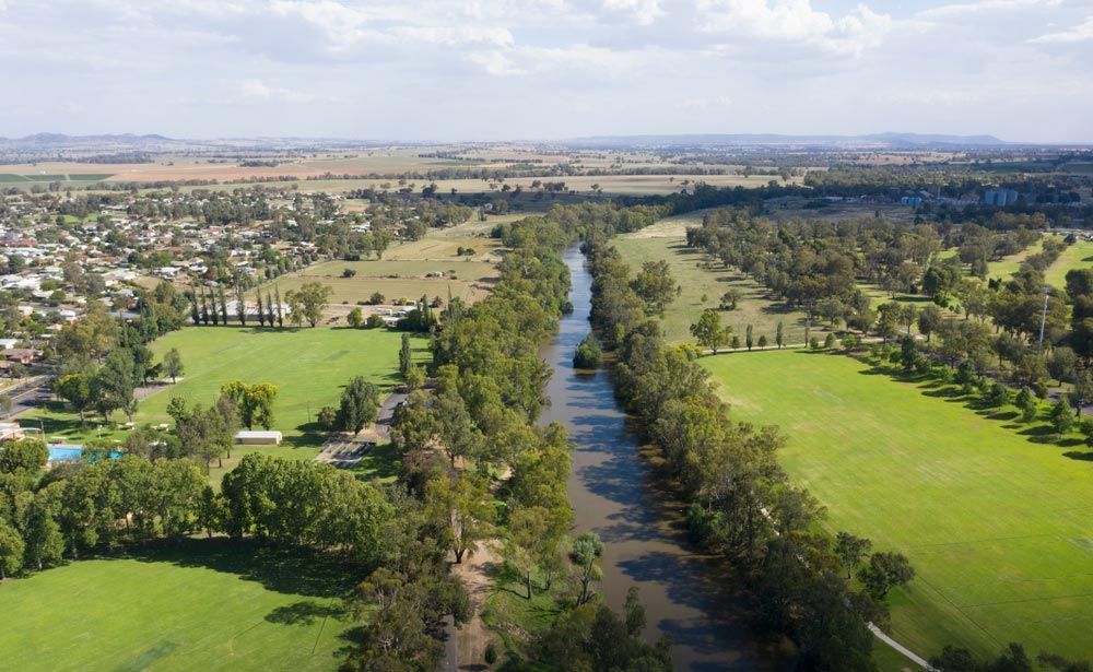 An Aerial View Of A River Surrounded By Trees And Grass — Gordy's Furniture Removals in Cowra, NSW
