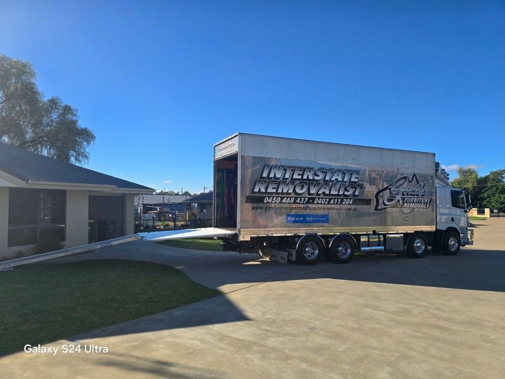 A Moving Truck is Parked in Front of a House — Gordy's Furniture Removals in Bathurst, NSW