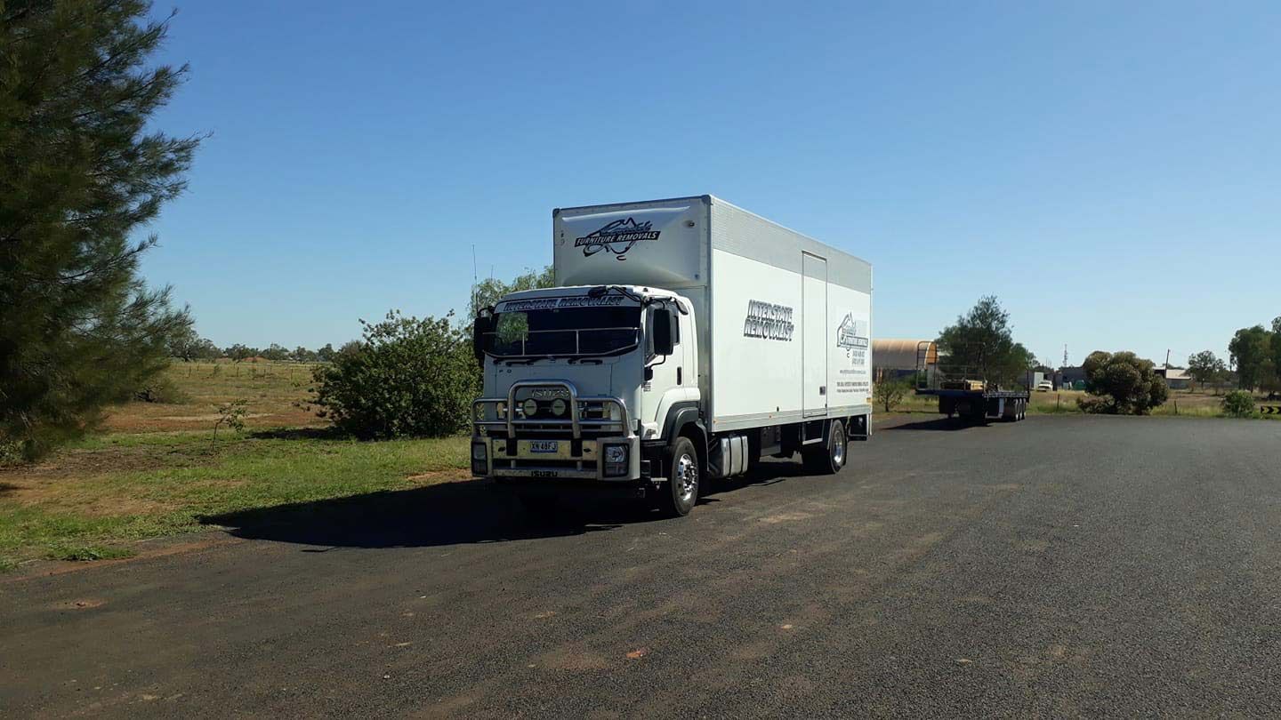 A White Moving Truck Is Parked On The Side Of The Road — Gordy's Furniture Removals in Bathurst, NSW
