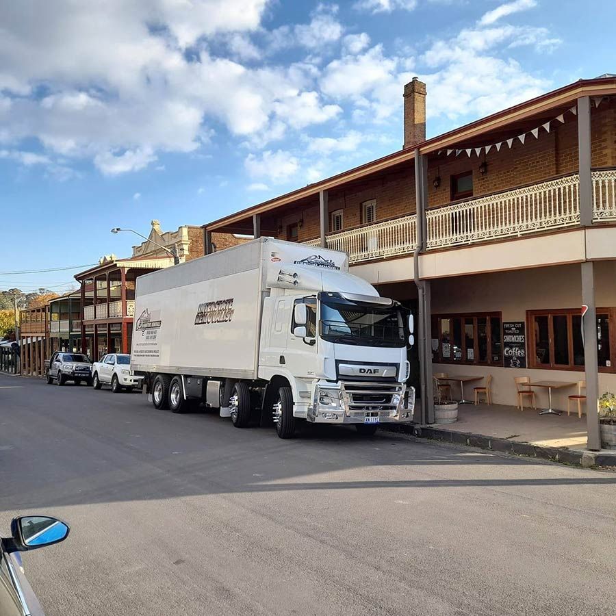 A Large White Truck Is Parked In Front Of A Building — Gordy's Furniture Removals in Bathurst, NSW