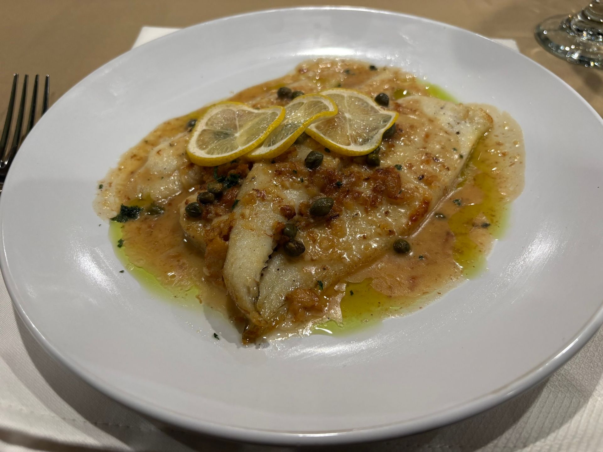 Plated gourmet vegetables and fish in creamy sauce, garnished with dill on a white plate