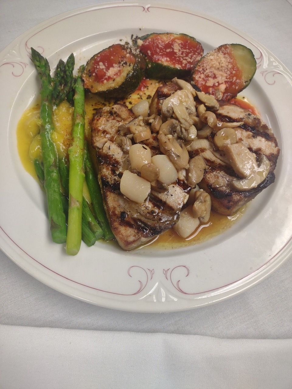 Grilled asparagus, eggplant, tomatoes, and mushrooms on a white plate