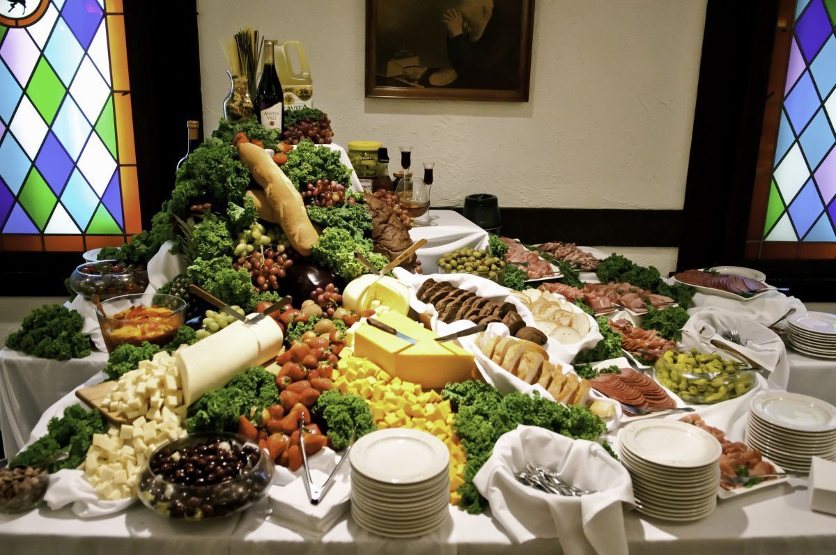 Buffet table with fruit, cheese, bread, and appetizers in a decorated dining room