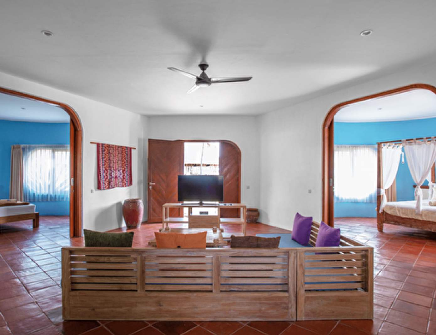 A living room with a wooden couch and a ceiling fan
