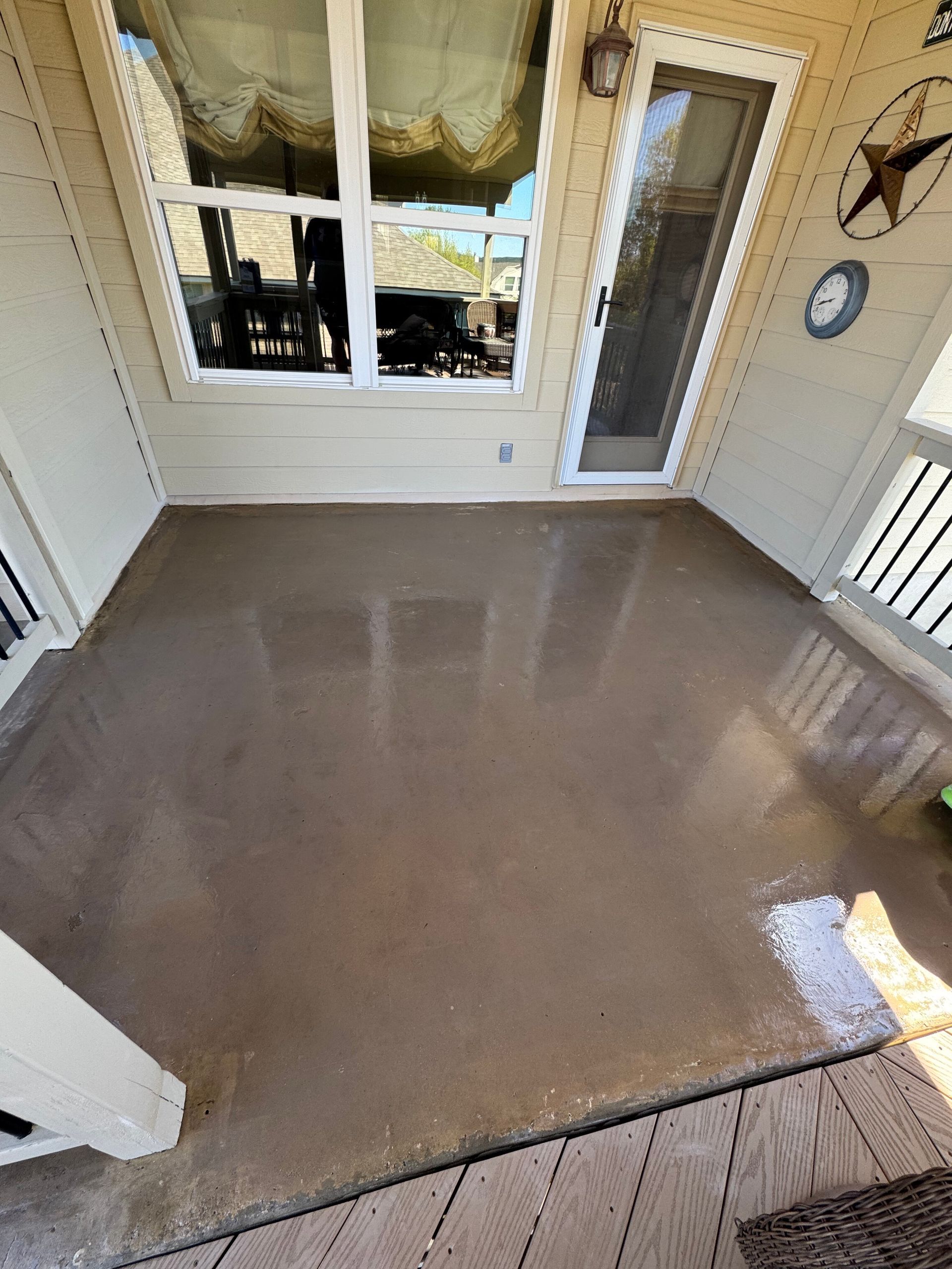Wet beige porch floor with a window and door leading outside